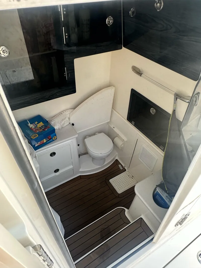Slide: The Image of 2022 Cobia 350 Center Console boat interior with toilet and storage cabinets. - 7