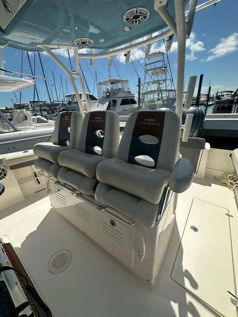 Slide: The Image of 2022 Cobia 350 Center Console boat interior with cushioned seating at marina. - 8