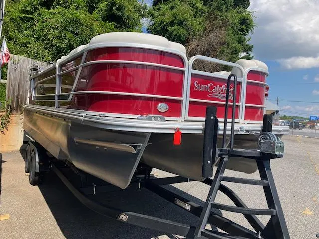 Slide: The Image of 2021 G3 Suncatcher Fusion 322RC pontoon boat on trailer, red exterior, parked outdoors. - 2