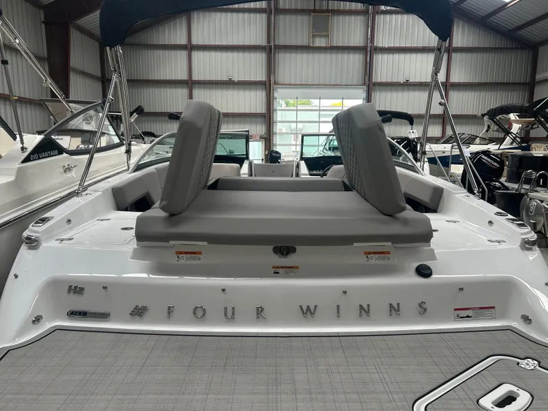 Slide: The Image of 2025 Four Winns H2 boat interior with gray seating in a showroom. - 17
