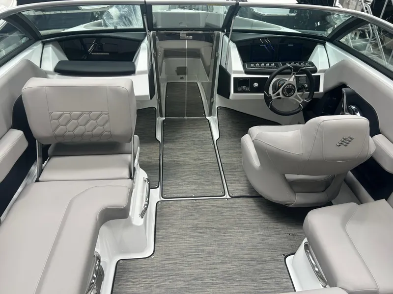 Slide: The Image of 2025 Four Winns H2 boat interior with gray seating in a showroom. - 7