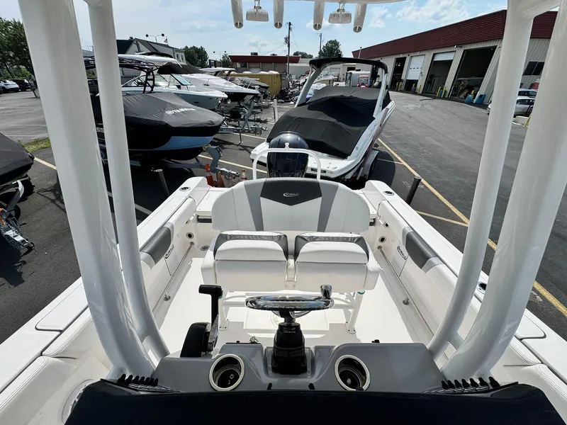 Slide: The Image of 2022 Robalo R230 Center Console boat in a marina, showcasing sleek design and seating. - 15