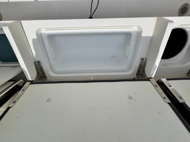 Slide: The Image of 2022 Robalo R230 Center Console boat storage compartment, open and empty. - 19