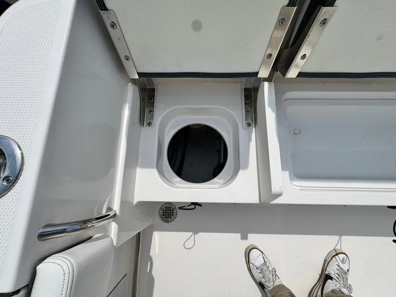 Slide: The Image of 2022 Robalo R230 Center Console boat deck with storage compartments and stainless steel fittings. - 20