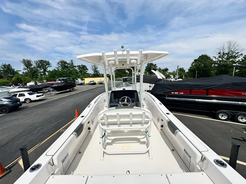 Slide: The Image of 2022 Robalo R230 Center Console boat in parking lot, surrounded by cars and trees. - 9