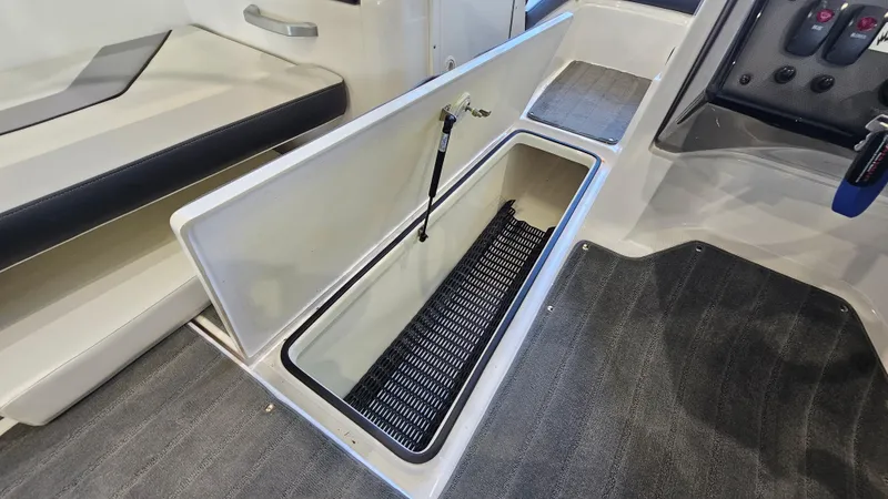 Slide: The Image of 2017 Yamaha Boats AR195 interior storage compartment with open lid, showcasing spacious design. - 19