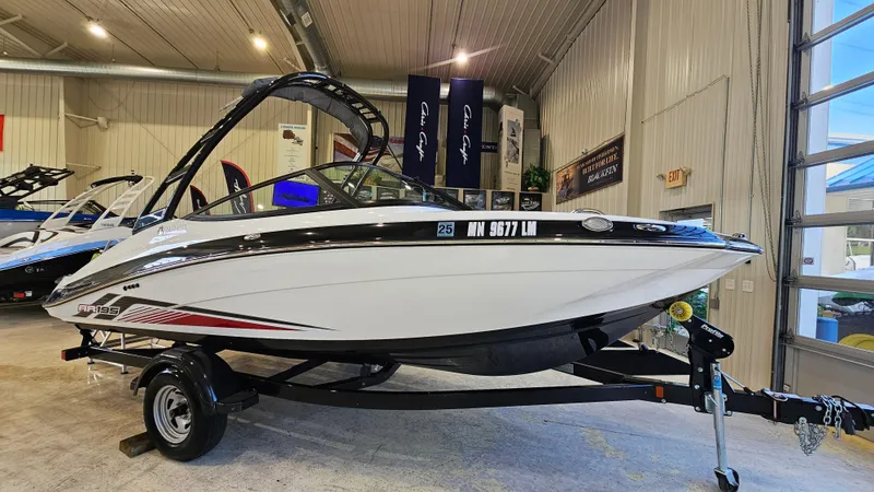 Slide: The Image of 2017 Yamaha Boats AR195 displayed indoors on a trailer. - 2