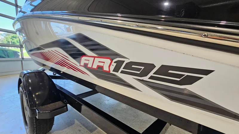 Slide: The Image of 2017 Yamaha Boats AR195 side view with bold graphics in a garage setting. - 26