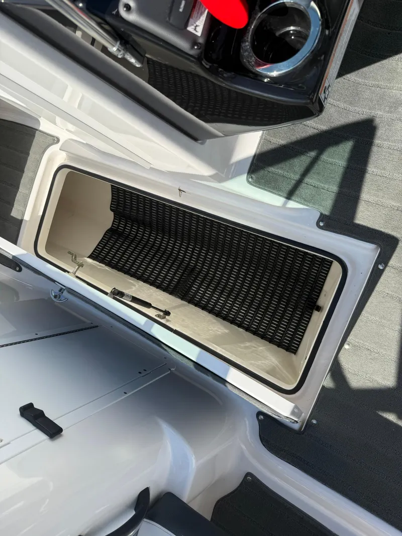 Slide: The Image of Open storage compartment on a 2016 Yamaha Boats 212X, showcasing interior details. - 16
