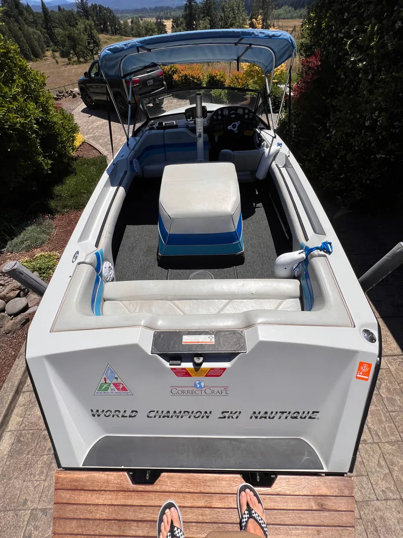 Slide: The Image of 1991 Correct Craft Ski Nautique 196 boat with blue and white interior, parked outdoors. - 2