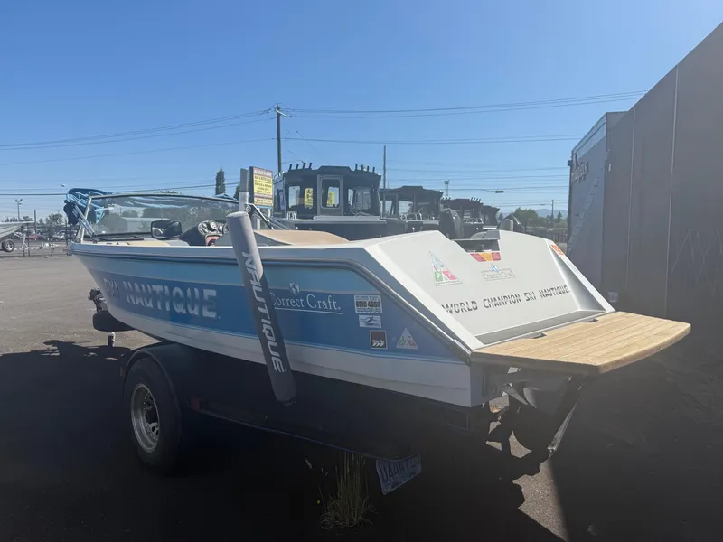 Slide: The Image of 1991 Correct Craft Ski Nautique 196 boat on trailer, parked outdoors under clear sky. - 4