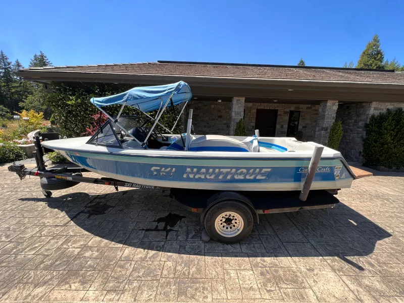 Slide: The Image of 1991 Correct Craft Ski Nautique 196 boat on trailer, blue and white, parked outdoors. - 6