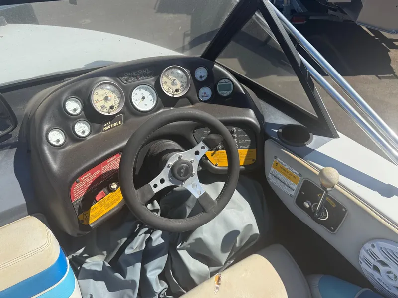 Slide: The Image of 1991 Correct Craft Ski Nautique 196 dashboard with steering wheel and gauges. - 7