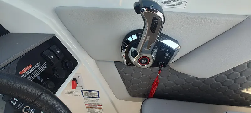 Slide: The Image of 2023 Sea Ray SDX 270 boat control panel with throttle and safety features. - 12