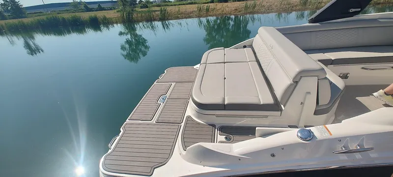 Slide: The Image of 2023 Sea Ray SDX 270 boat with spacious seating and sleek design on calm water. - 5