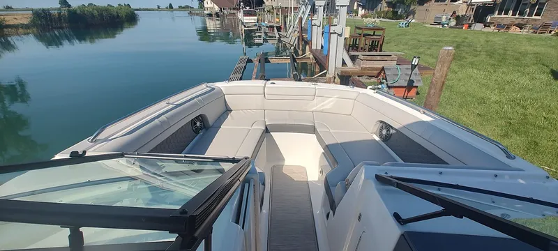 Slide: The Image of 2023 Sea Ray SDX 270 boat with spacious seating, docked by a serene waterfront. - 8