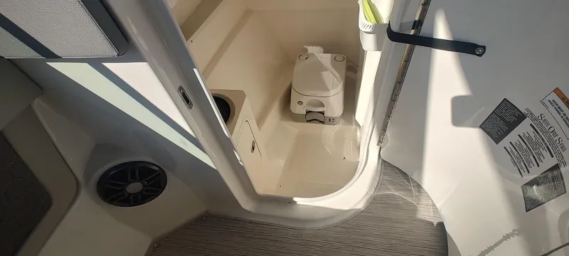 Slide: The Image of 2023 Sea Ray SDX 270 boat interior with compact toilet and speaker. - 9