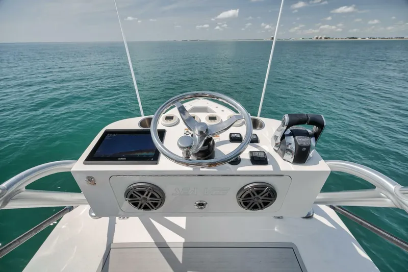 Slide: The Image of Helm of 2020 SeaVee 39 boat with steering wheel and controls, overlooking ocean. - 44