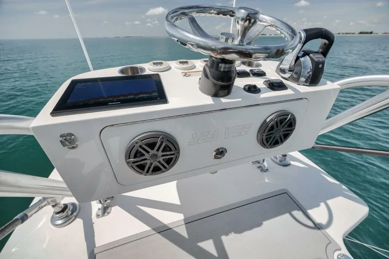 Slide: The Image of 2020 SeaVee 39 boat helm with steering wheel, controls, and navigation display on open water. - 45