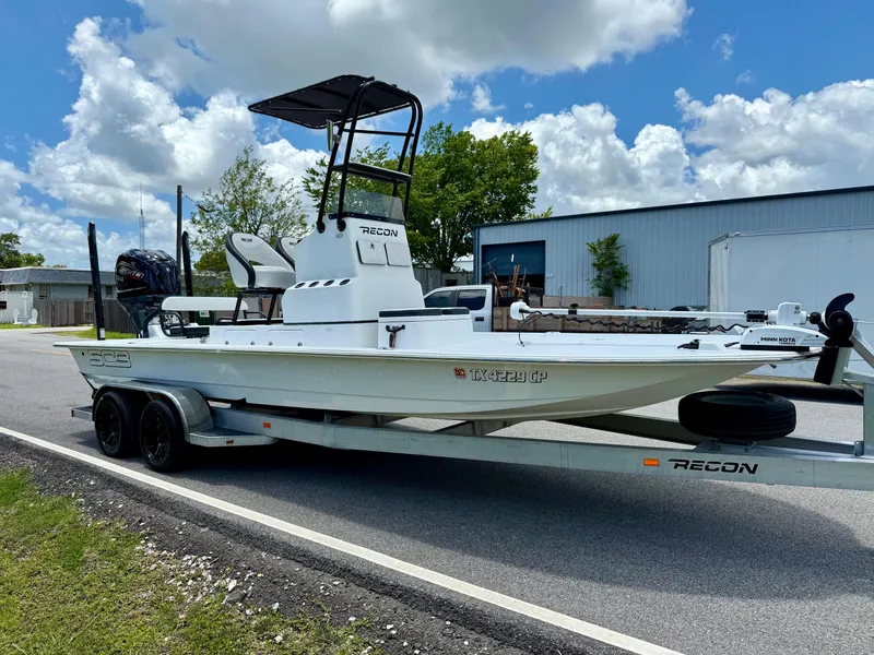 Slide: The Image of 2015 SCB Recon boat on trailer, parked on road under cloudy sky. - 5