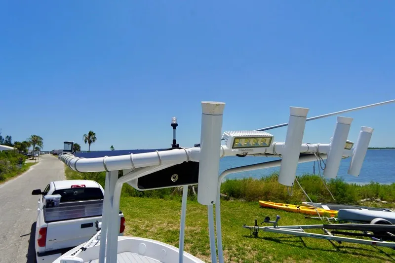 Slide: The Image of 2003 Key Largo 186 CC boat on trailer near waterfront, clear blue sky. - 10