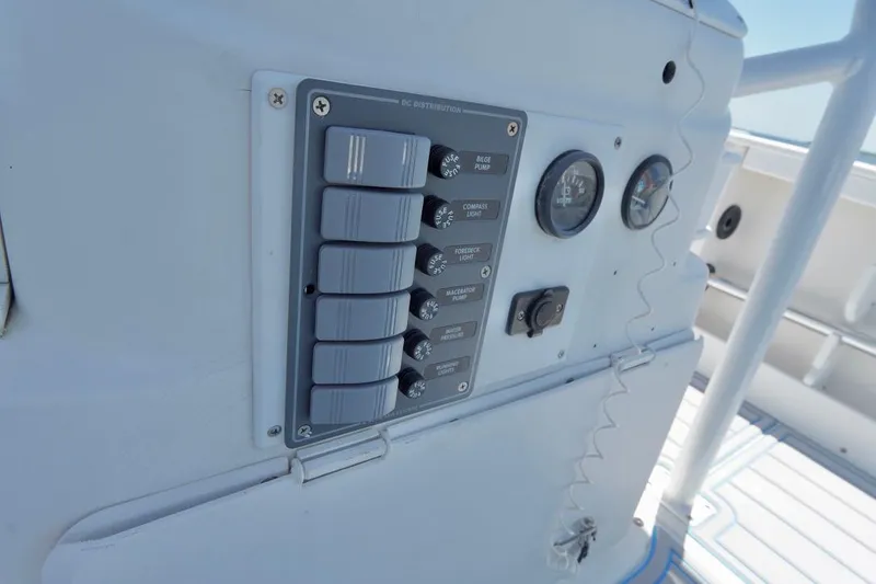 Slide: The Image of Control panel on 2003 Key Largo 186 CC boat dashboard with switches and gauges. - 17