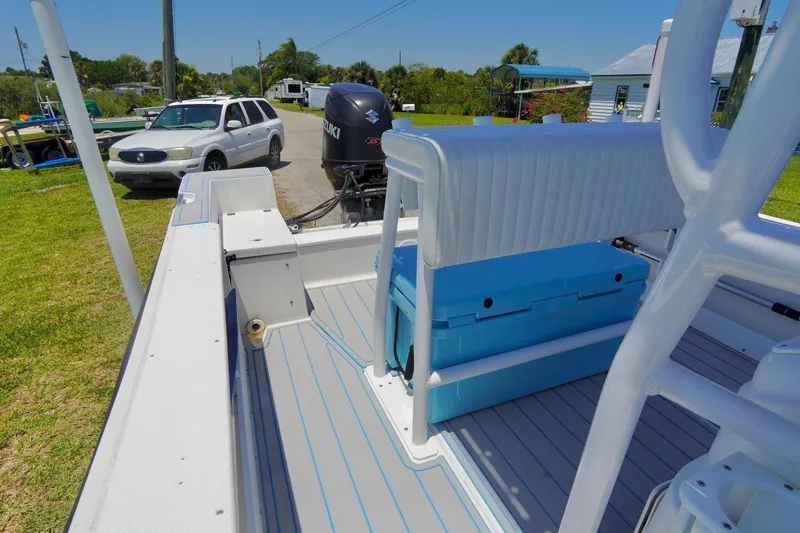 Slide: The Image of 2003 Key Largo 186 CC boat interior with seating and outboard motor, parked near vehicles. - 20