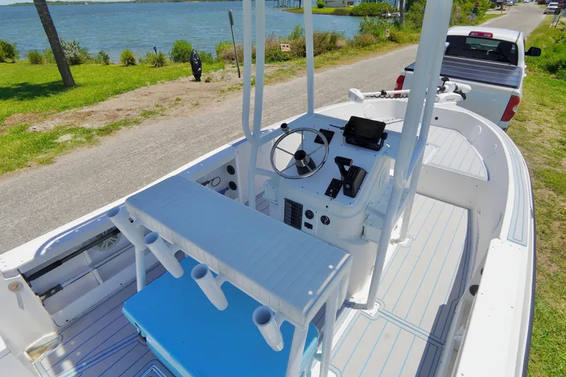 Slide: The Image of 2003 Key Largo 186 CC boat interior with steering console, near a waterfront road. - 21