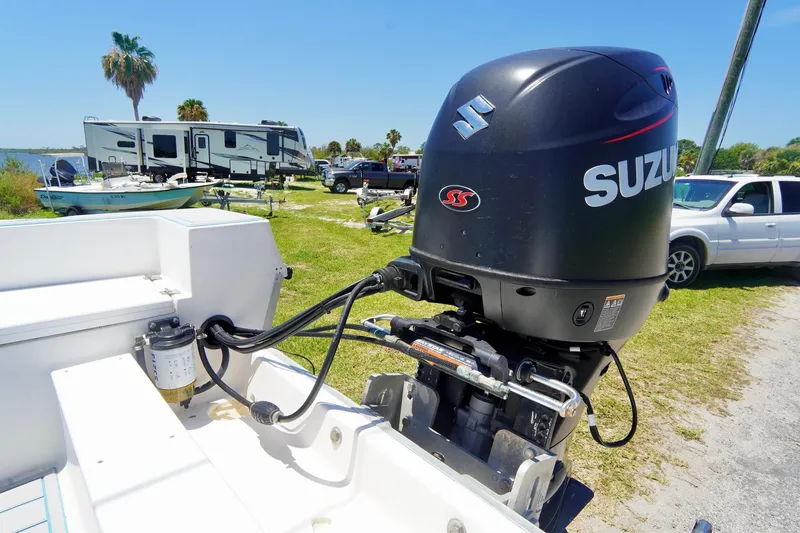 Slide: The Image of 2003 Key Largo 186 CC boat with Suzuki outboard motor in a sunny outdoor setting. - 23