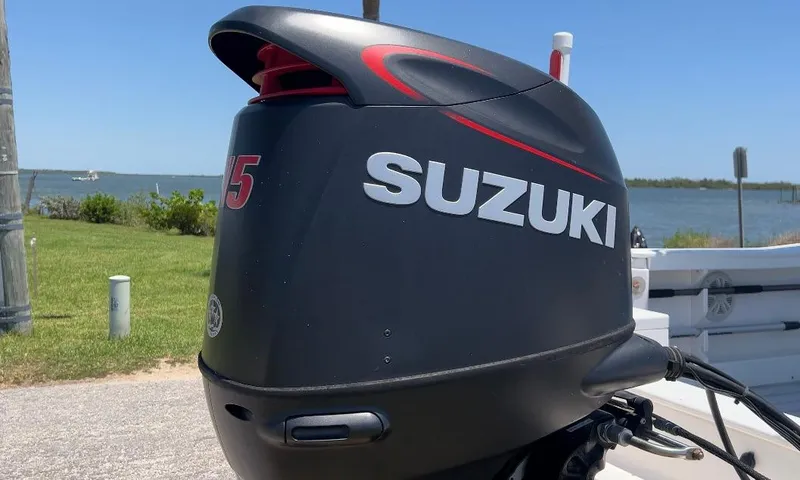 Slide: The Image of Suzuki outboard motor on 2003 Key Largo 186 CC boat, near waterfront. - 24