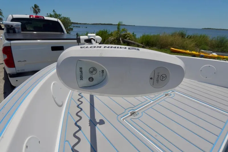 Slide: The Image of 2003 Key Largo 186 CC boat with Minn Kota Riptide motor, parked near a scenic waterfront. - 5