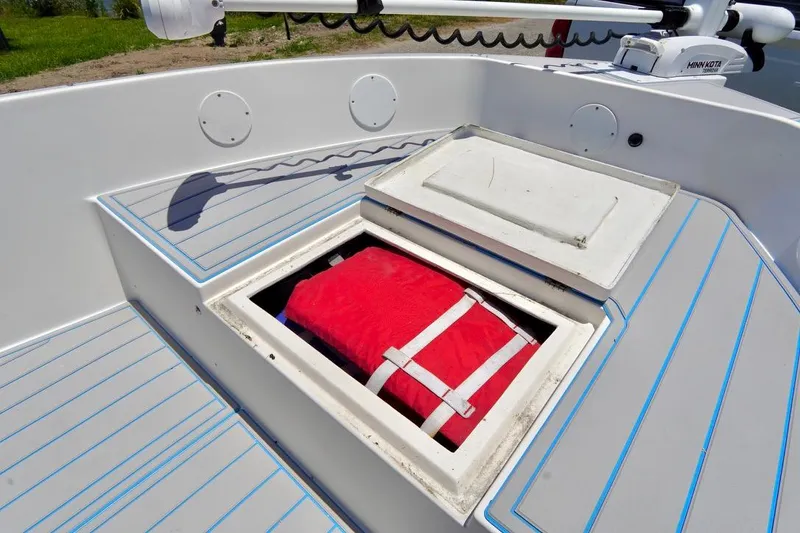 Slide: The Image of 2003 Key Largo 186 CC boat with open storage compartment and red life jacket. - 6