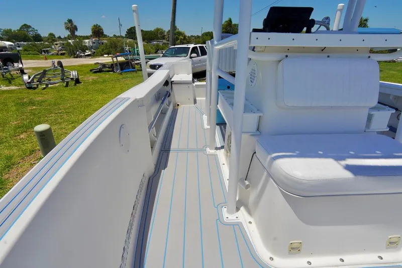Slide: The Image of 2003 Key Largo 186 CC boat interior with white seating and deck, parked outdoors. - 7