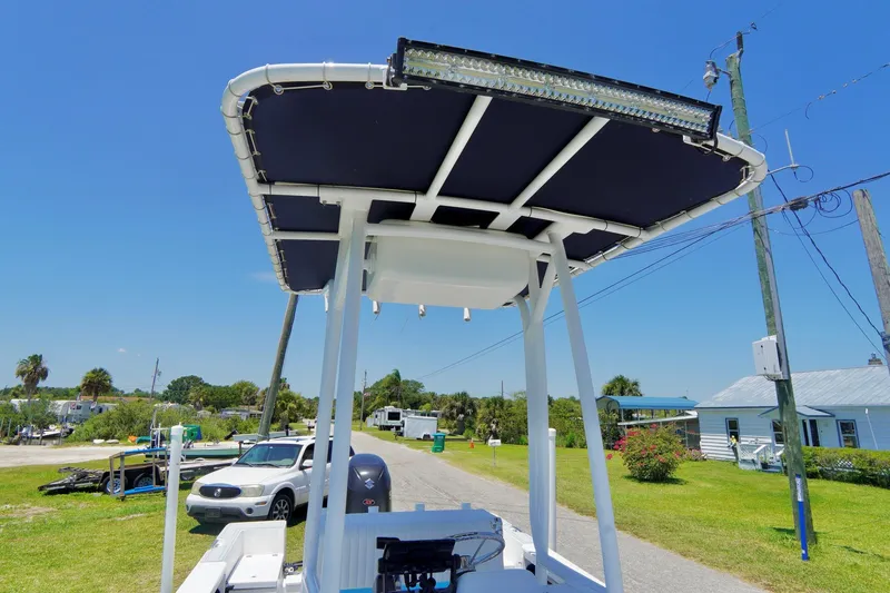 Slide: The Image of 2003 Key Largo 186 CC boat with T-top and LED light bar on a sunny day. - 9