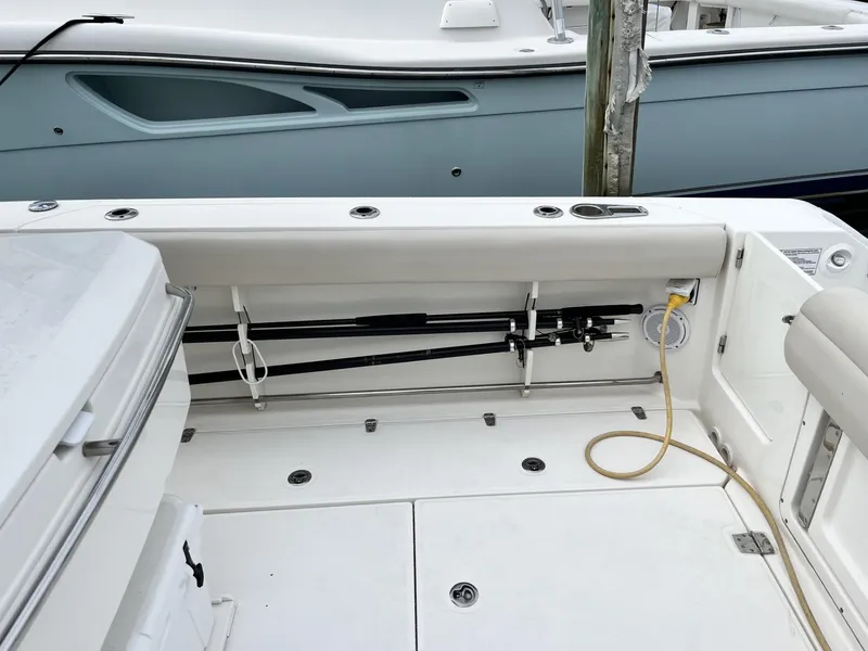 Slide: The Image of 2018 Boston Whaler 330 Outrage boat interior with fishing rod storage and seating. - 10
