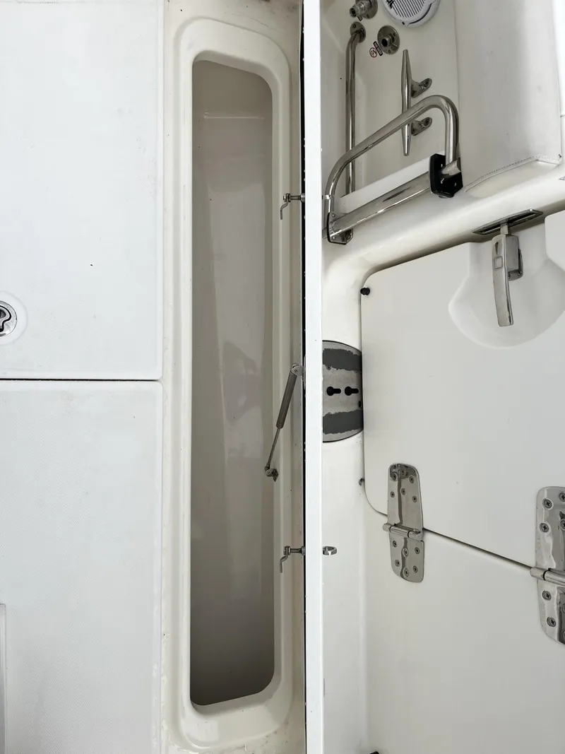 Slide: The Image of 2018 Boston Whaler 330 Outrage interior storage compartment with stainless steel fixtures. - 11