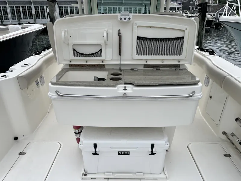 Slide: The Image of 2018 Boston Whaler 330 Outrage boat interior with Yeti cooler and storage compartments. - 15