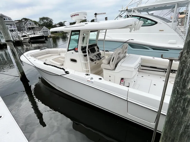 Slide: The Image of 2018 Boston Whaler 330 Outrage boat docked at marina, featuring sleek design and modern equipment. - 2