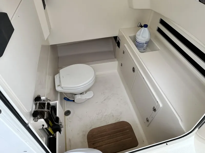 Slide: The Image of 2018 Boston Whaler 330 Outrage boat interior with toilet and storage area. - 23