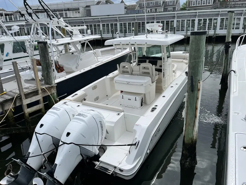 Slide: The Image of 2018 Boston Whaler 330 Outrage docked, featuring dual outboard engines. - 6