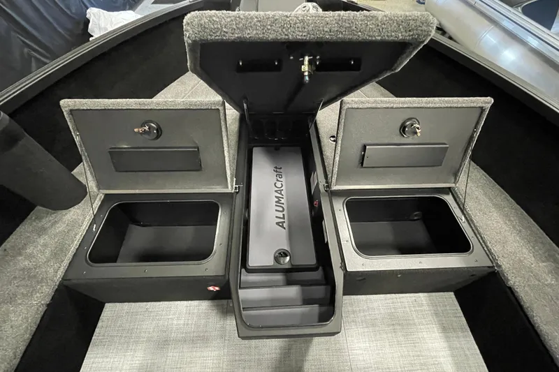 Slide: The Image of 2026 Alumacraft Competitor 185X Tiller boat storage compartments with open lids. - 13