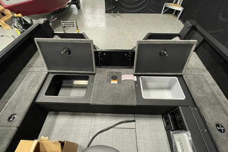 Slide: The Image of 2026 Alumacraft Competitor 185X Tiller interior with storage compartments and equipment. - 15