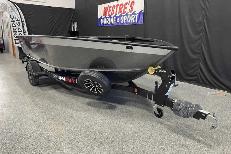 Slide: The Image of 2026 Alumacraft Competitor 185X Tiller boat on trailer in showroom. - 2