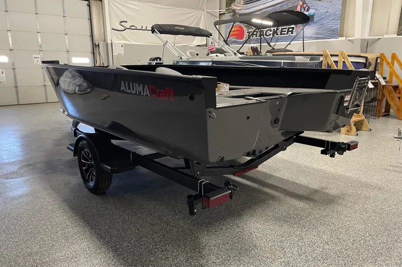 Slide: The Image of 2026 Alumacraft Competitor 185X Tiller boat on trailer in showroom. - 3