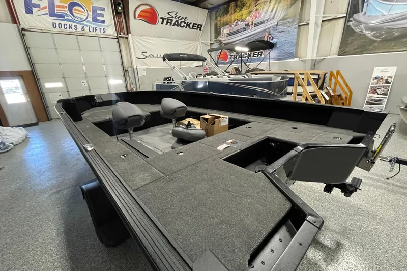 Slide: The Image of 2026 Alumacraft Competitor 185X Tiller boat in showroom, featuring spacious interior and seating. - 4