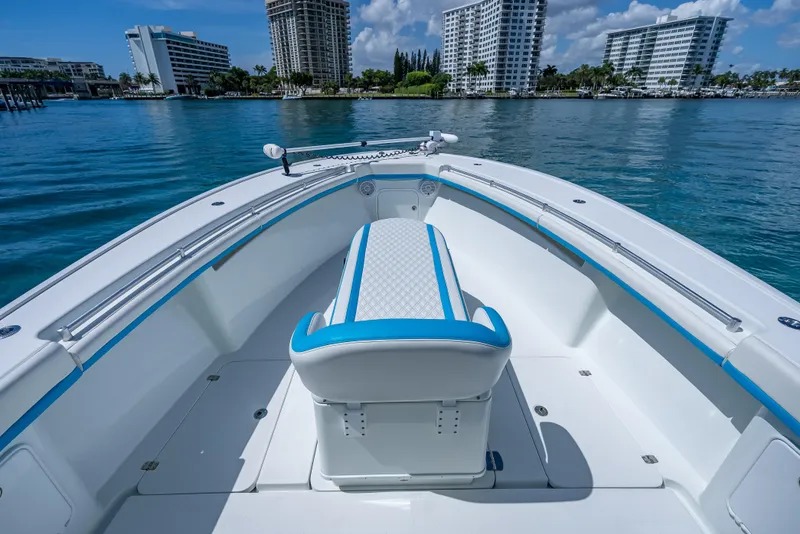 Slide: The Image of 2016 Yellowfin 39 Offshore boat interior with blue accents, docked near modern buildings. - 17