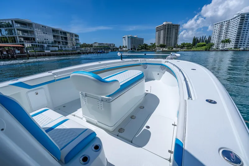 Slide: The Image of 2016 Yellowfin 39 Offshore boat on calm water, with modern buildings in the background. - 20