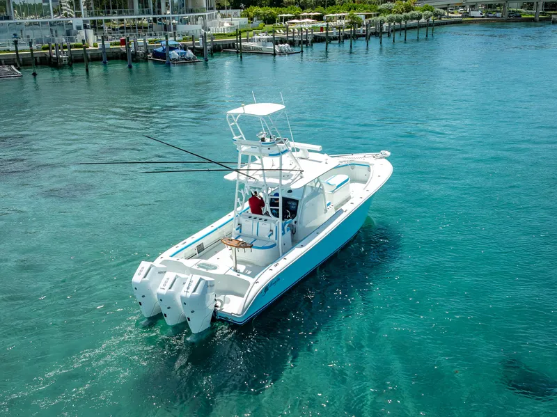 Slide: The Image of 2016 Yellowfin 39 Offshore boat cruising in clear blue water near a marina. - 3
