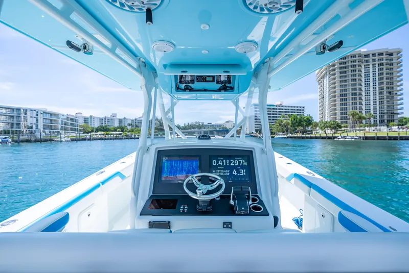 Slide: The Image of 2016 Yellowfin 39 Offshore boat dashboard with navigation system, cruising in a coastal cityscape. - 8