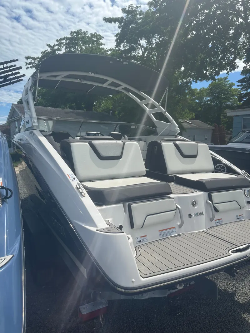 Slide: The Image of 2021 Yamaha Boats 252S with sleek design and spacious seating, parked outdoors. - 4